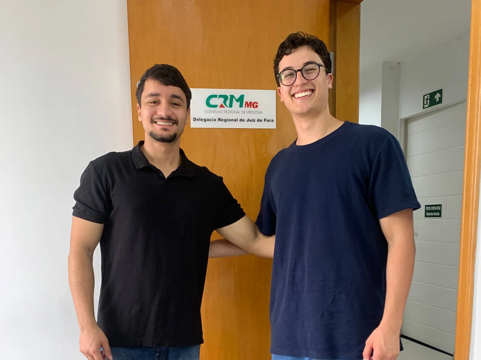 Davi e Marco em frente à Delegacia Regional do CRM-MG de Juiz de Fora, no dia do registro como médicos